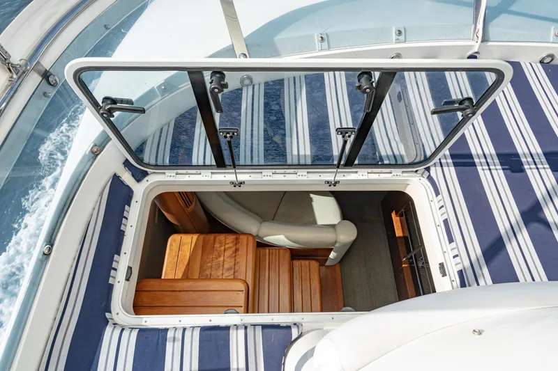 Slide: The Image of 2002 Fairline Squadron 58 yacht interior with striped cushions and open hatch. - 23