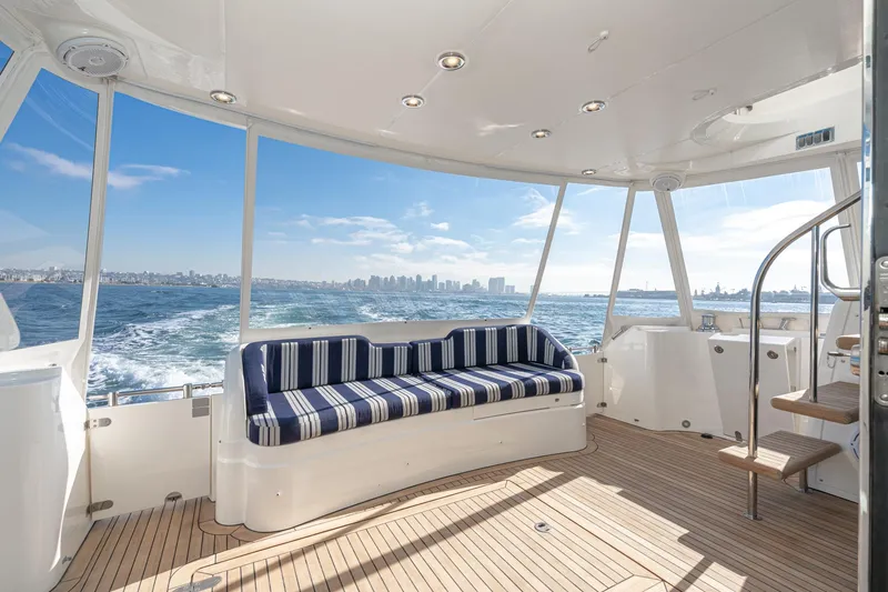 Slide: The Image of Luxurious 2002 Fairline Squadron 58 yacht interior with striped seating, ocean view, and city skyline. - 31