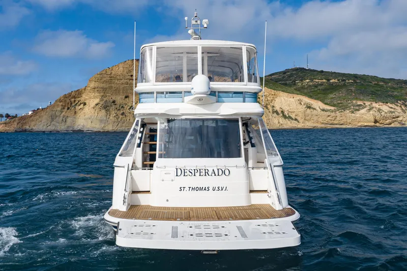 Slide: The Image of 2002 Fairline Squadron 58 yacht "Desperado" on the water near rocky coastline. - 4