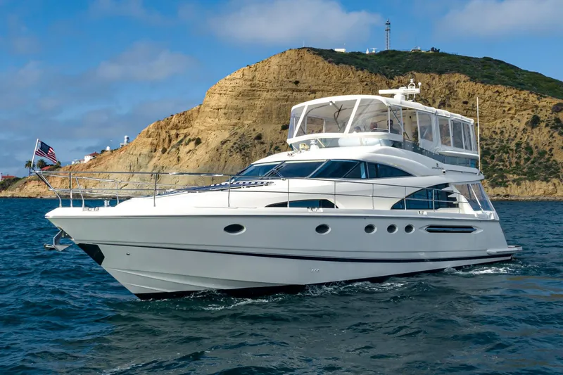 Slide: The Image of Luxury 2002 Fairline Squadron 58 yacht cruising near rocky coastline. - 7