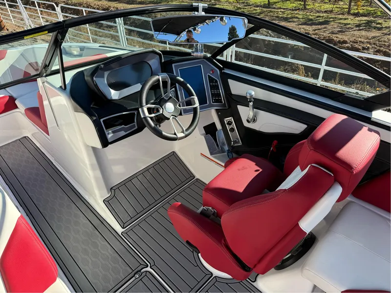 Slide: The Image of 2022 MasterCraft XT24 boat interior with red seats and modern dashboard. - 12
