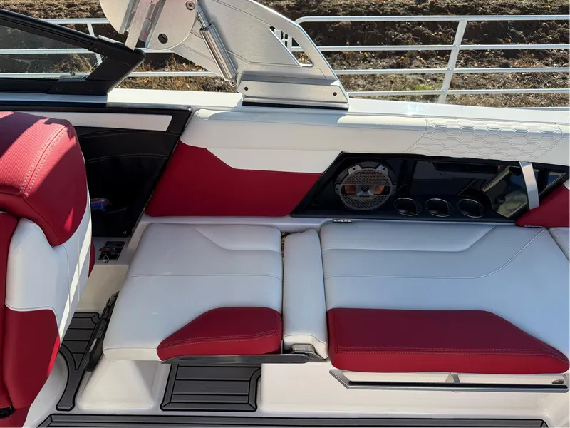 Slide: The Image of 2022 MasterCraft XT24 boat interior with red and white seating and modern dashboard. - 13