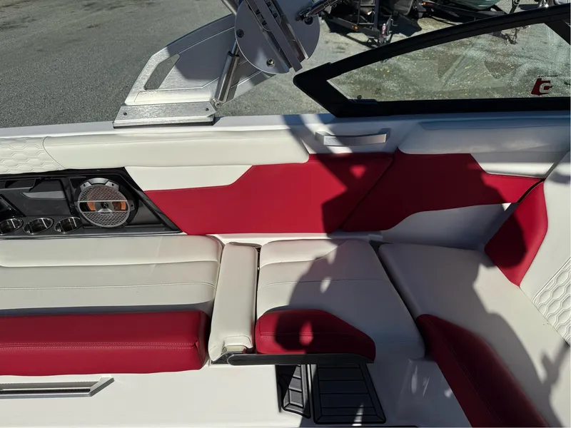 Slide: The Image of 2022 MasterCraft XT24 boat interior with red and white seating and speaker system. - 17