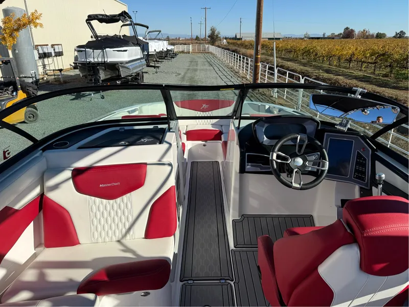 Slide: The Image of 2022 MasterCraft XT24 boat interior with red and white seating, modern dashboard, and steering wheel. - 19