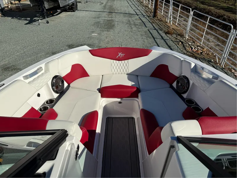 Slide: The Image of 2022 MasterCraft XT24 boat interior with red and white seating, cup holders, and speakers. - 20