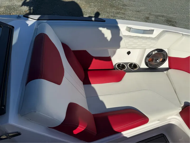Slide: The Image of 2022 MasterCraft XT24 boat interior with red and white seating, cup holders, and speaker. - 21