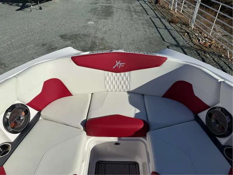 Slide: The Image of 2022 MasterCraft XT24 boat interior with red and white seating and built-in speakers. - 23