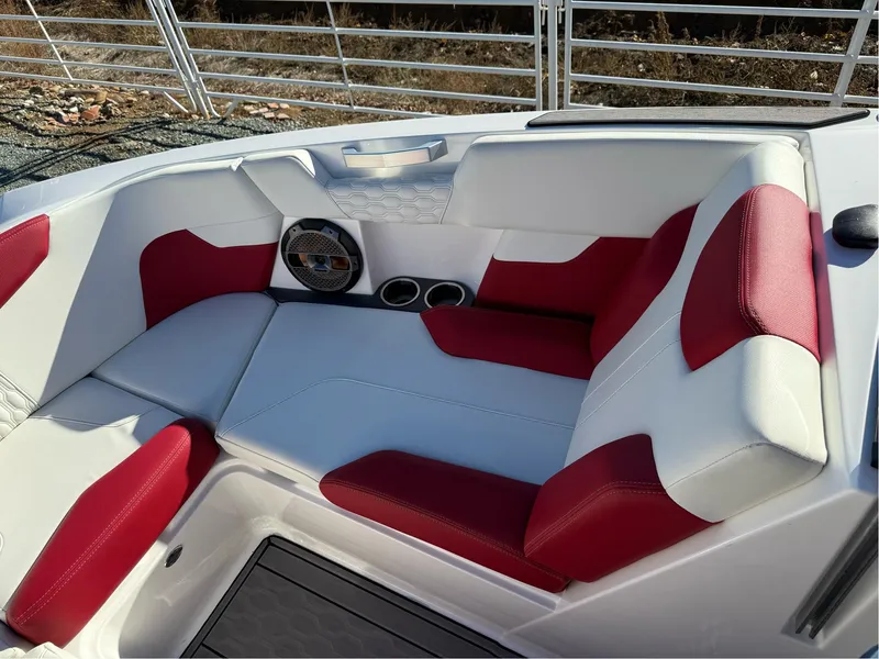 Slide: The Image of 2022 MasterCraft XT24 boat interior with red and white seating and cup holders. - 25