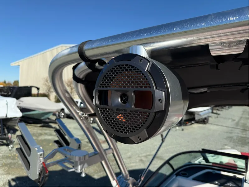 Slide: The Image of 2022 MasterCraft XT24 boat with mounted speaker on metal frame, outdoor setting. - 26