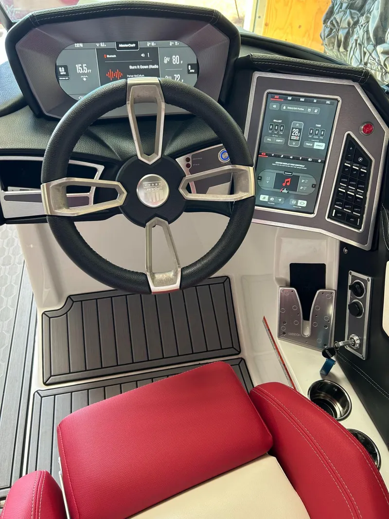 Slide: The Image of 2022 MasterCraft XT24 boat dashboard with steering wheel and digital controls. - 30