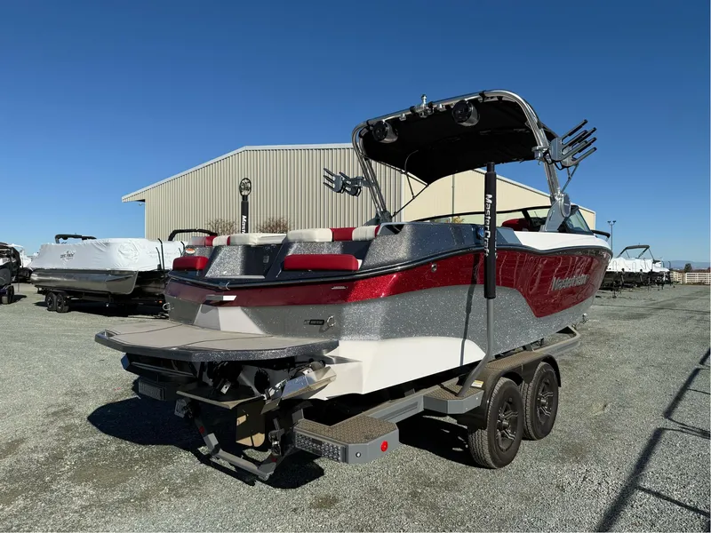 Slide: The Image of 2022 MasterCraft XT24 boat on trailer, red and silver, parked outdoors. - 5
