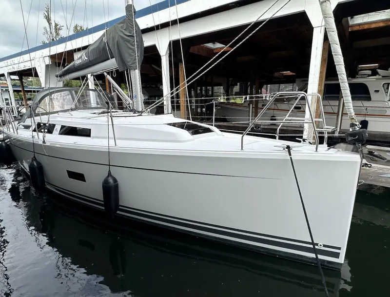 Slide: The Image of 2019 Hanse 348 sailboat docked in marina, featuring sleek white hull and modern design. - 1