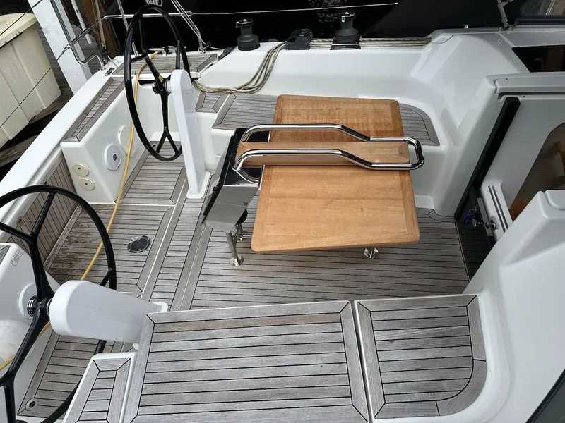 Slide: The Image of 2019 Hanse 348 yacht cockpit with dual steering wheels and wooden table. - 18