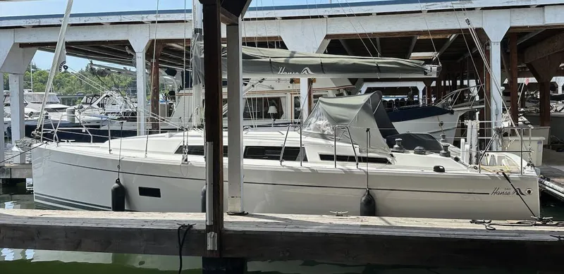 Slide: The Image of 2019 Hanse 348 sailboat docked in a marina, sheltered under a covered slip. - 2