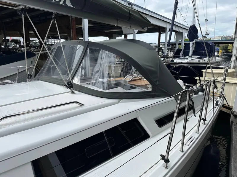 Slide: The Image of 2019 Hanse 348 sailboat docked, featuring sleek design and protective canopy. - 26