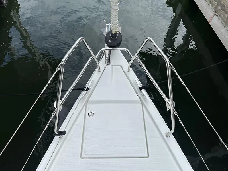 Slide: The Image of Bow of 2019 Hanse 348 sailboat with stainless steel railings and calm water reflection. - 31