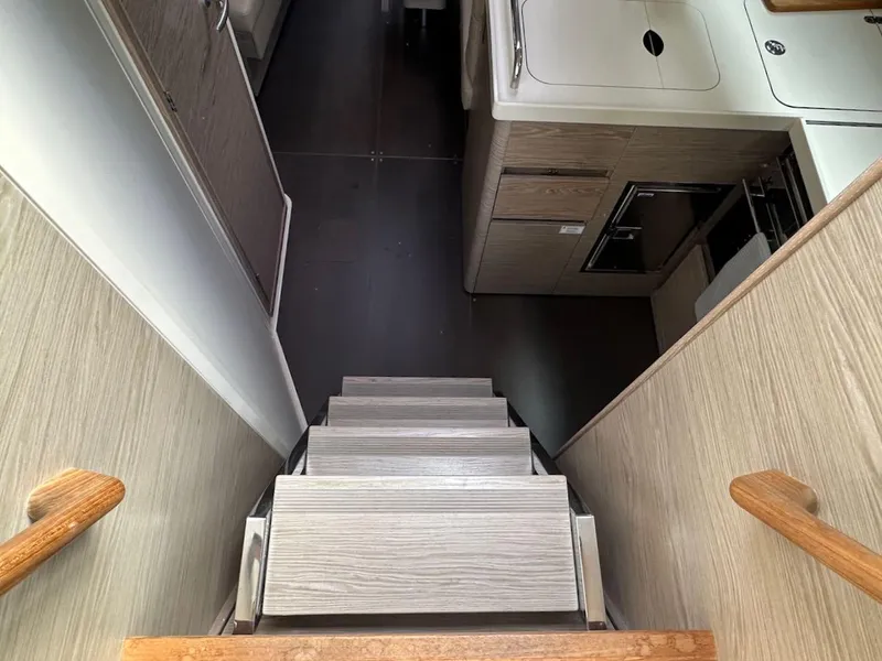 Slide: The Image of Interior stairs of 2019 Hanse 348 yacht, leading to modern kitchen area. - 38
