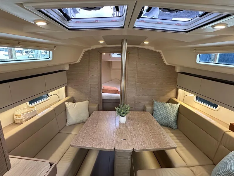 Slide: The Image of 2019 Hanse 348 yacht interior with dining area, skylights, and cozy seating. - 41