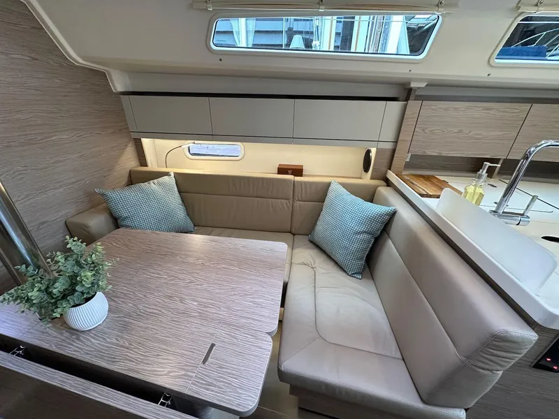 Slide: The Image of 2019 Hanse 348 yacht interior with beige seating, wooden table, and modern decor. - 43