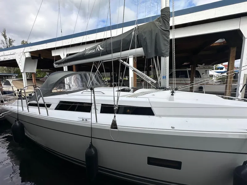 Slide: The Image of 2019 Hanse 348 sailboat docked at marina, featuring sleek design and modern rigging. - 6