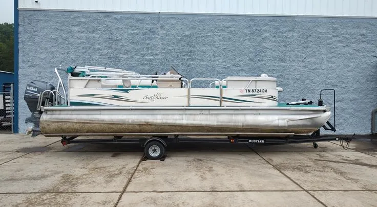 Slide: The Image of 2006 SunChaser 825F pontoon boat on trailer, parked outside a building. - 1