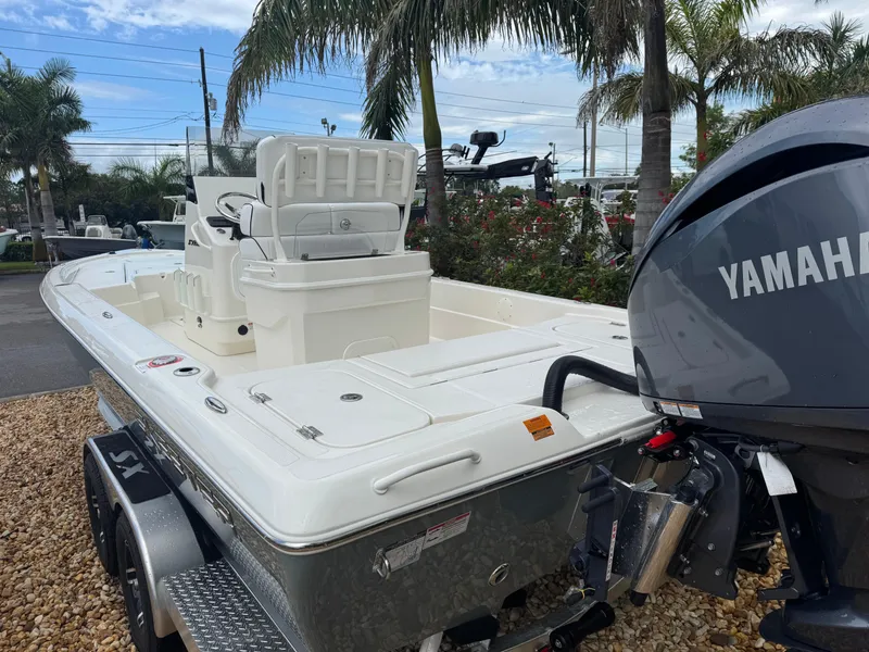 Slide: The Image of 2025 Skeeter SX 241 boat with Yamaha engine, parked outdoors on gravel, surrounded by palm trees. - 15