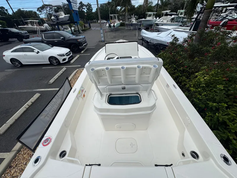 Slide: The Image of 2025 Skeeter SX 241 boat with open storage compartment, parked in a lot with cars. - 17