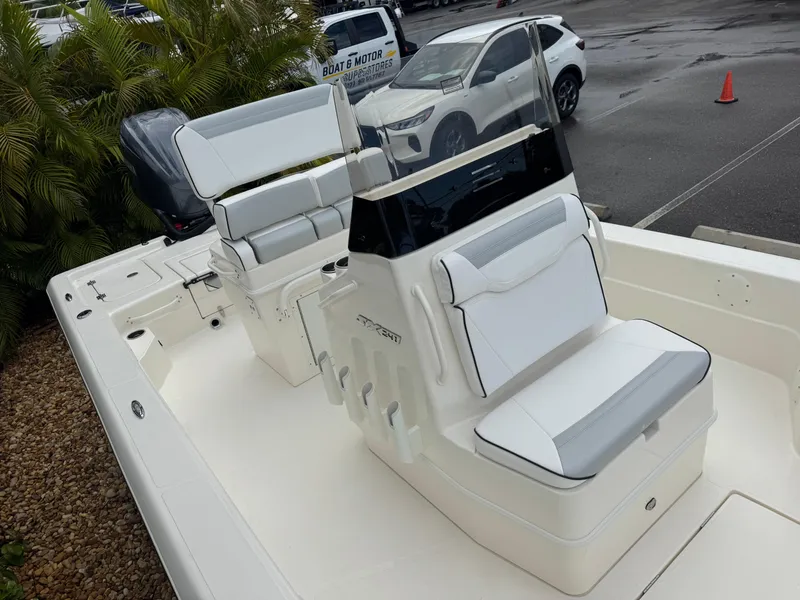 Slide: The Image of 2025 Skeeter SX 241 boat interior with white seating and console, parked outdoors. - 27