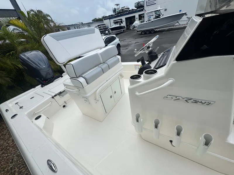 Slide: The Image of 2025 Skeeter SX 241 boat interior with seating and storage, displayed at a dealership. - 29