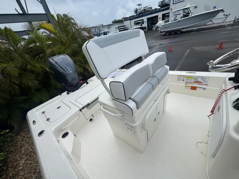 Slide: The Image of 2025 Skeeter SX 241 boat interior with seating and motor, parked near dealership. - 30