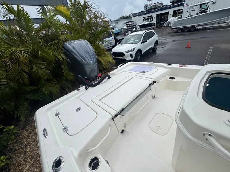 Slide: The Image of 2025 Skeeter SX 241 boat with outboard motor, parked near a car and palm trees. - 31