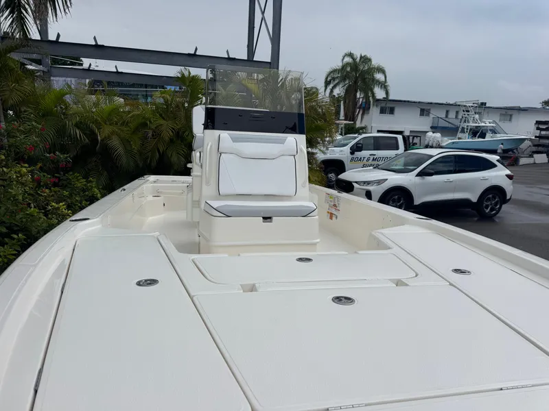 Slide: The Image of 2025 Skeeter SX 241 boat with sleek design, parked outdoors near vehicles and greenery. - 8