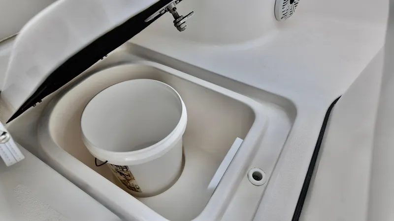 Slide: The Image of 2020 Sea Fox 248 Commander storage compartment with a white bucket inside. - 8