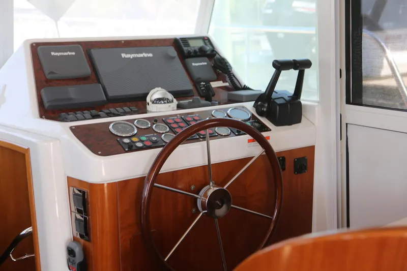 Slide: The Image of 2007 Beneteau Swift Trawler 42 helm with wooden steering wheel and navigation equipment. - 16