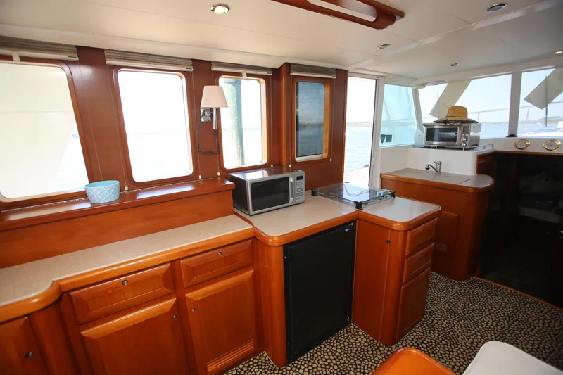 Slide: The Image of Interior of 2007 Beneteau Swift Trawler 42 with kitchen appliances and wooden cabinetry. - 24