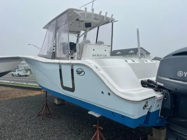 Slide: The Image of 2020 Sea Fox 288 Commander boat on stands, featuring a sleek white and blue design. - 2