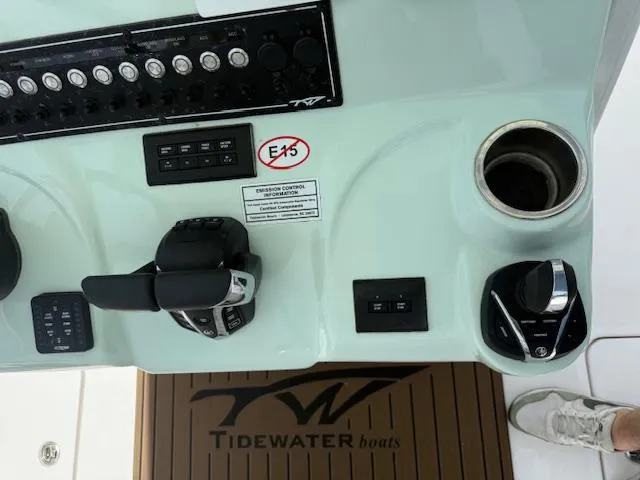 Slide: The Image of Control panel of 2024 Tidewater 292 CC Adventure boat with throttle and cup holder. - 11