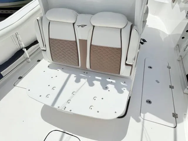 Slide: The Image of 2024 Tidewater 292 CC Adventure boat seating with white and brown cushioned design. - 4