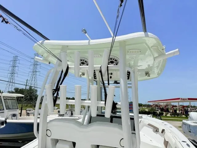 Slide: The Image of 2024 Tidewater 292 CC Adventure boat with rod holders and speakers, under a clear blue sky. - 5