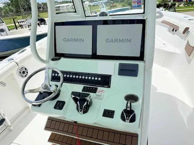 Slide: The Image of 2024 Tidewater 292 CC Adventure boat dashboard with dual Garmin displays and controls. - 6