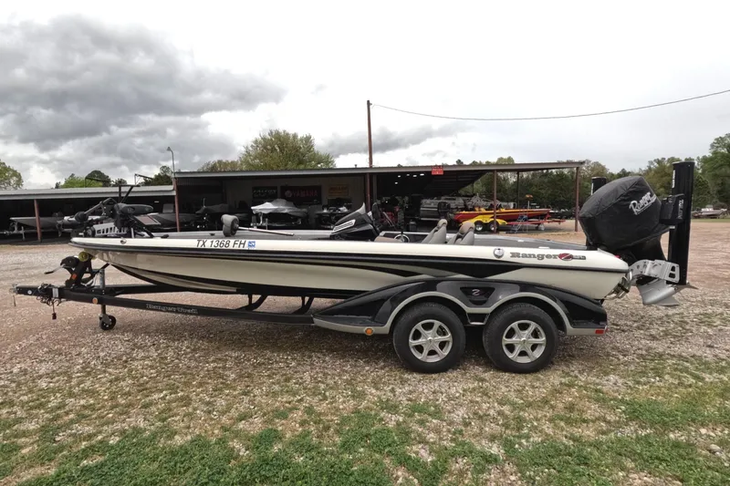 Slide: The Image of 2014 Ranger Z521C Comanche boat on trailer, parked outdoors under cloudy sky. - 1