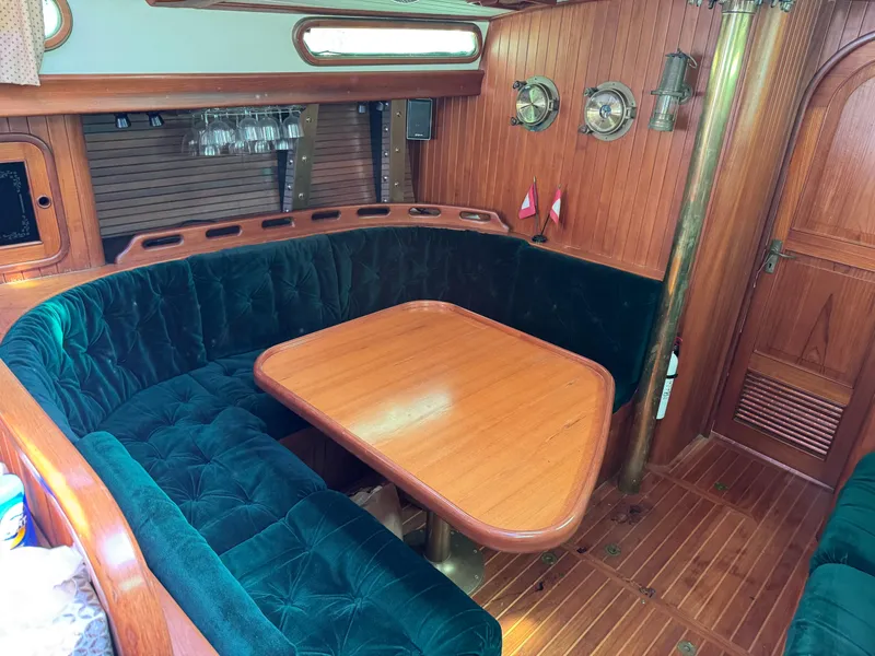 Slide: The Image of Interior of 1987 Hans Christian Christina 40 yacht with wooden table and green cushioned seating. - 12