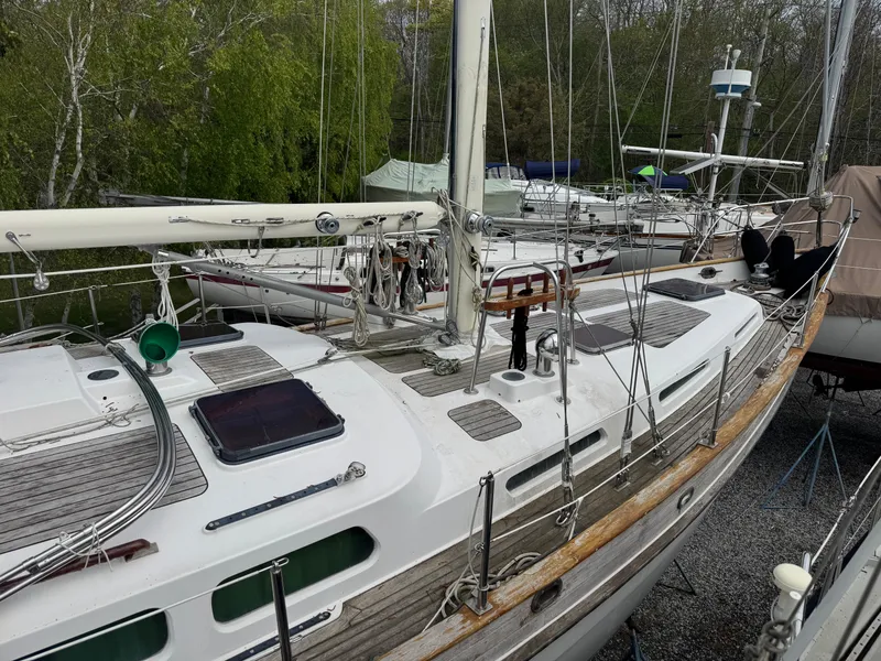 Slide: The Image of 1987 Hans Christian Christina 40 sailboat docked, featuring a sleek white deck and wooden accents. - 2