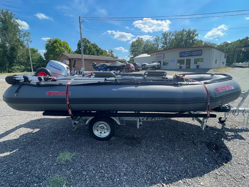The Image of 2021 Saturn HD430 inflatable boat on trailer, parked outdoors under a clear sky. - 1