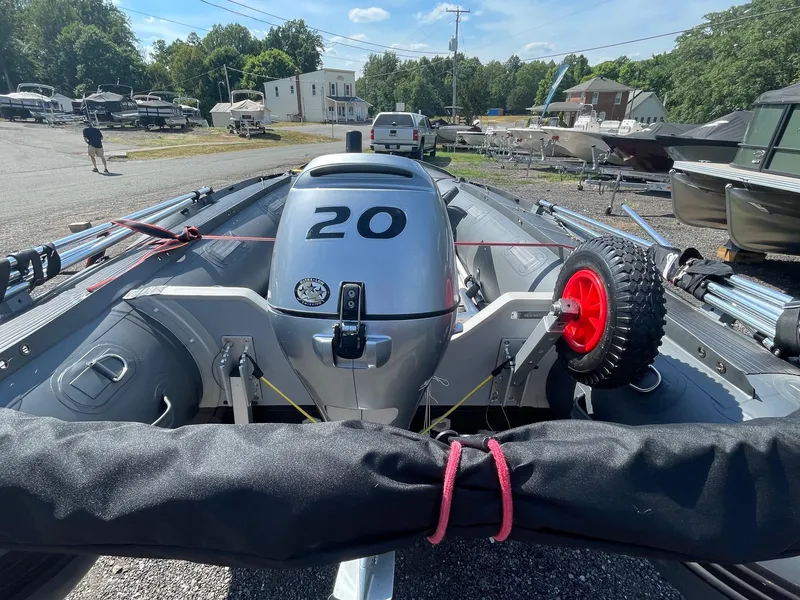Slide: The Image of Inflatable boat with a 20 HP outboard motor, Saturn HD430, 2021 model, in a marina setting. - 3