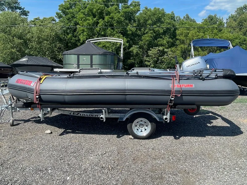 Slide: The Image of Inflatable Saturn HD430 boat on trailer, 2021 model, with Honda motor, parked outdoors. - 6