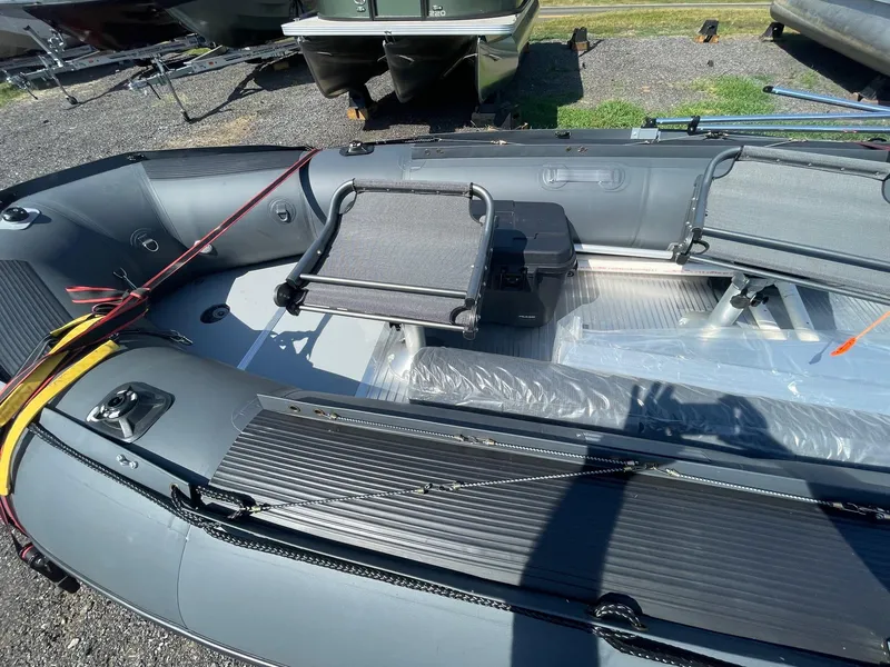 Slide: The Image of 2021 Saturn HD430 inflatable boat interior with seating and storage, displayed outdoors. - 8