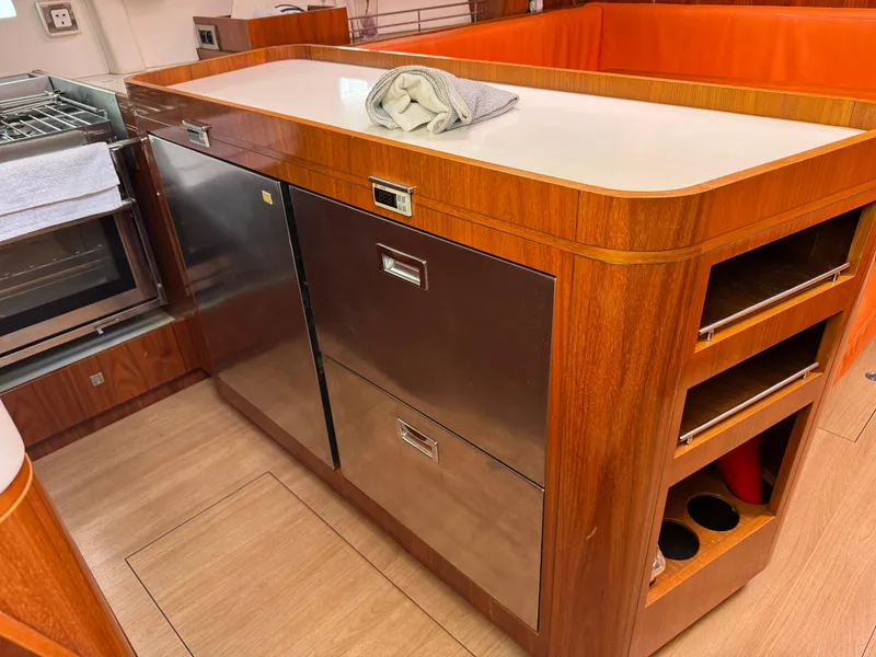 Slide: The Image of Modern kitchen area in a 2012 Amel 55 yacht with wood cabinetry and stainless steel appliances. - 10