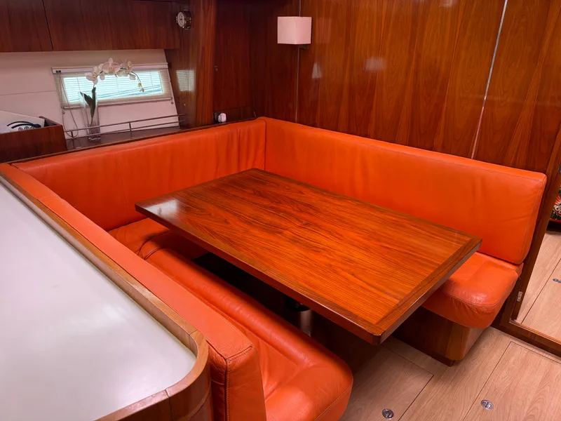 Slide: The Image of Luxurious Amel 55 yacht interior with orange seating and wooden table, 2012 model. - 12