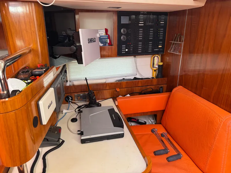 Slide: The Image of Navigation station in 2012 Amel 55 yacht with orange seating and electronic equipment. - 14